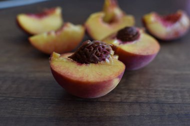 peach slices with pits on a wooden table