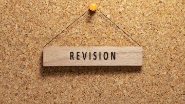 Revision word written on wooden surface. Hanging on wooden board. education and business