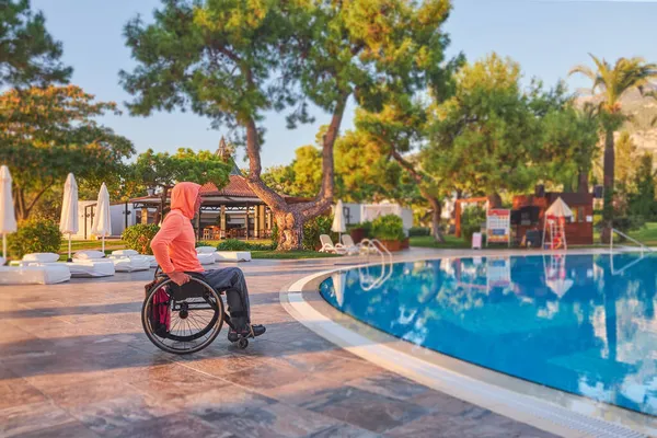 Beldibi, Türkiye, 20 Ekim 2021: Tekerlekli sandalyedeki adam sabahın erken saatlerinde otelden havuza
