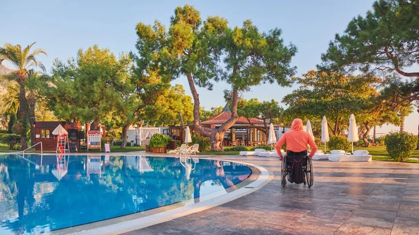 Beldibi, Türkiye, 20 Ekim 2021: Tekerlekli sandalyedeki adam sabahın erken saatlerinde otelden havuza