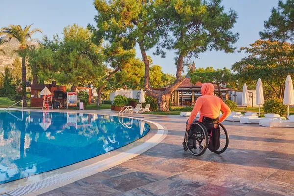 Beldibi, Türkiye, 20 Ekim 2021: Tekerlekli sandalyedeki adam sabahın erken saatlerinde otelden havuza