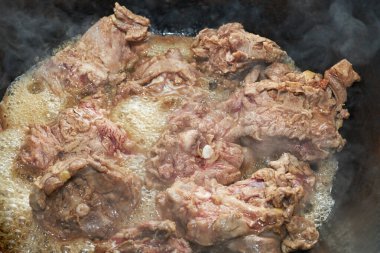 Genç kuzu parçaları kızgın yağda kızartılıyor.