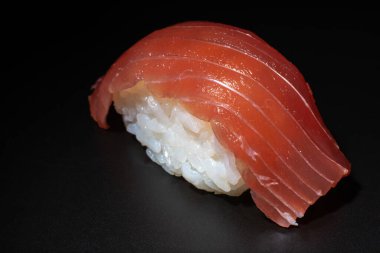 Siyah arkaplanda kırmızı ton balığı niguiri