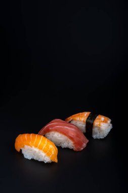 Siyah arkaplan ve aksesuar içeren çeşitli suşi istihkakı