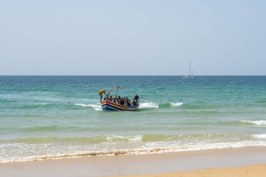 Arrival of a boat to the coast with people jumping