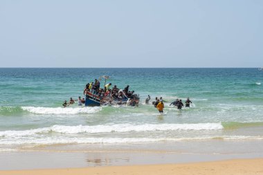 Arrival of a boat to the coast with people jumping