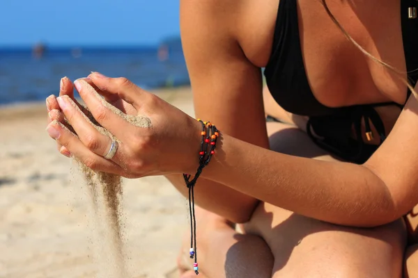 Lähikuva naisen kädet kaatamalla hiekkaa — kuvapankkivalokuva