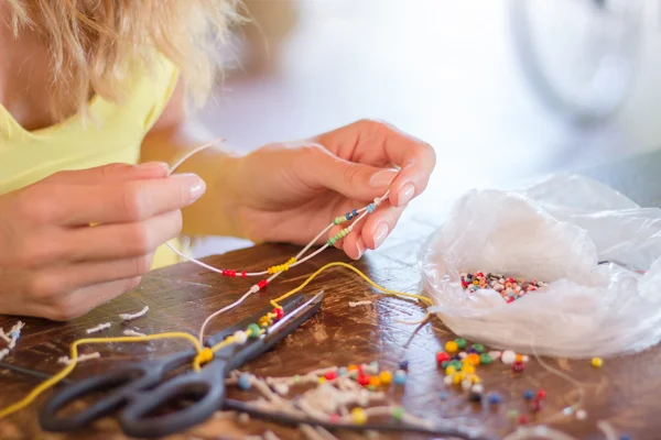 Woman making bracelet at home — Stock Photo, Image