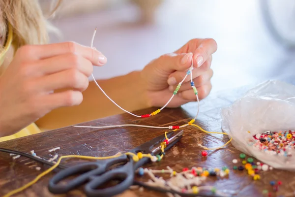 Woman making bracelet at home — Stock Photo, Image