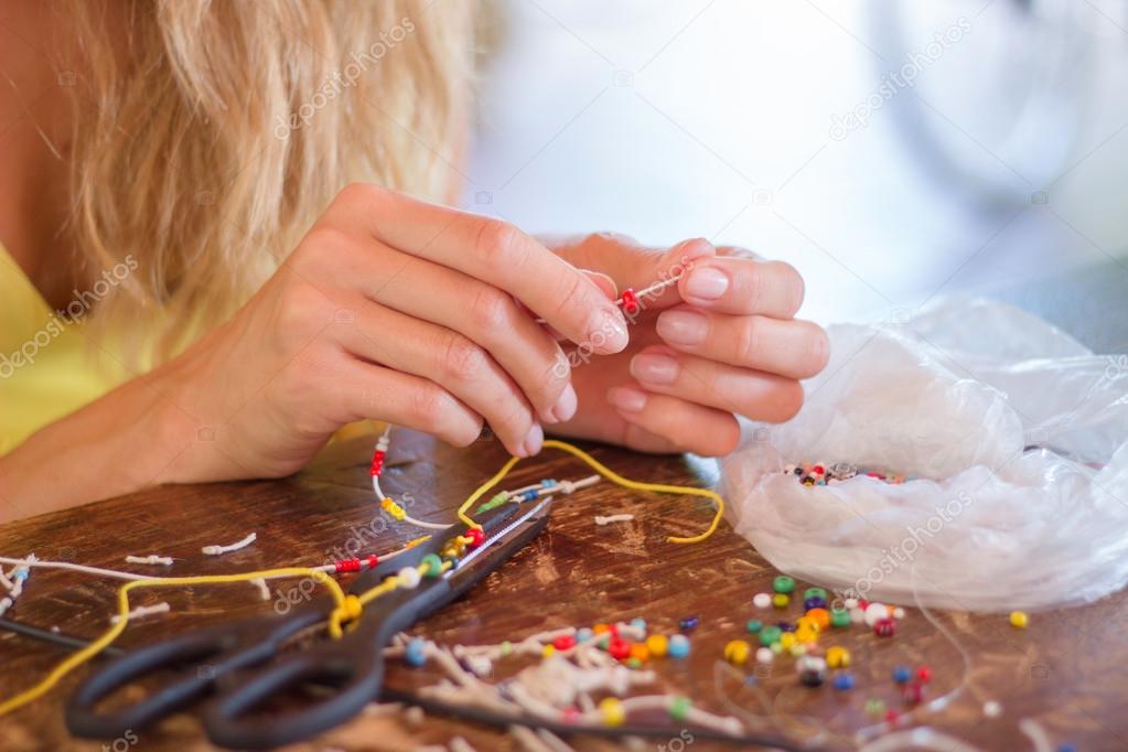 Woman making bracelet at home