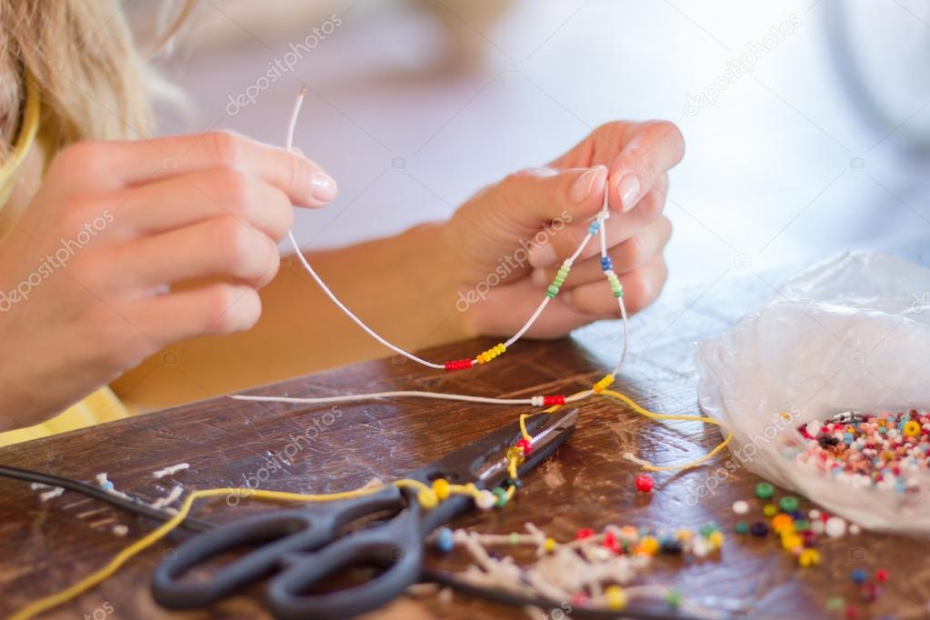 Woman making bracelet at home