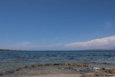 Güzel sahil, mavi deniz ve uzak dağlar. Güneşli bir günde mavi Adriyatik Denizi manzarası.