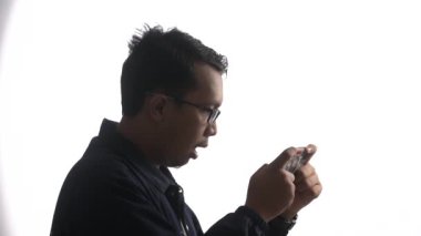 Gözlüklü bir gencin akıllı telefonuyla oyun oynadığı yüksek sesli bir video.