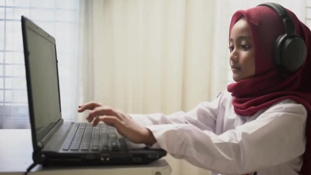 Ένα Χαριτωμένο Κοριτσάκι Που Φοράει Κόκκινη Μαντίλα Πληκτρολογώντας Φορητό Υπολογιστή — Αρχείο Βίντεο