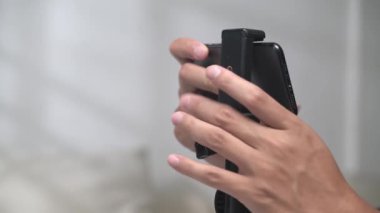 Bir el baş tripoda akıllı telefon koydu.