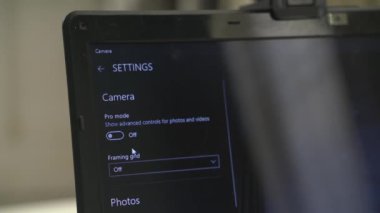 Adam ekranda görünen bir dizüstü bilgisayara kamera kuruyor.