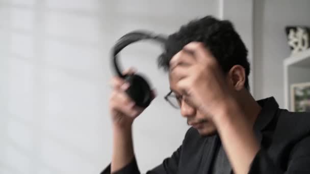 Müzik Dinlemek Için Gözlüklü Kulaklık Takan Asyalı Genç Bir Adam — Stok video