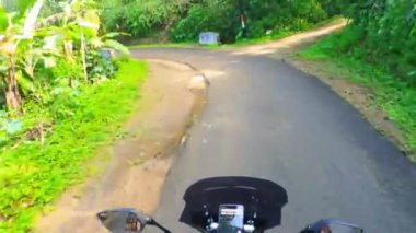 Yeşil bir yamaçta motosiklet sürmek, tepe yolu, gün boyunca orman yolu