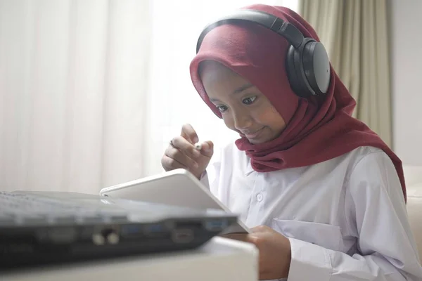 Seorang Gadis Kecil Yang Lucu Mengenakan Hijab Merah Melakukan Sesuatu — Stok Foto