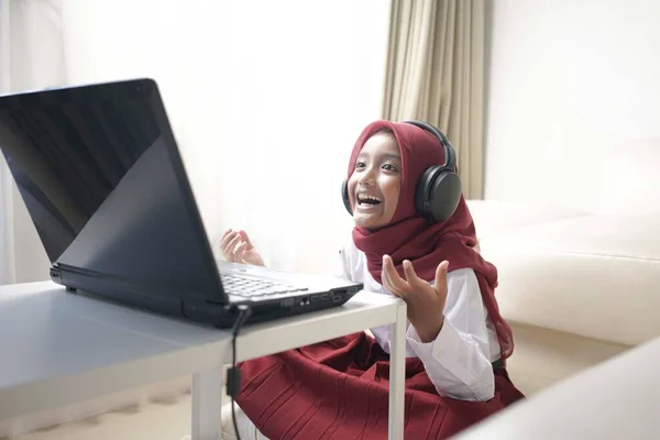Cheerful Little Girl Wearing Red Hijab Doing Something Her Laptop — Stockfoto