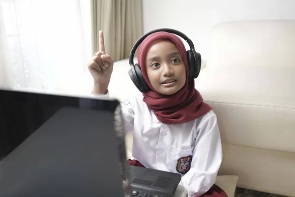 Seorang Gadis Kecil Yang Lucu Mengenakan Hijab Merah Melakukan Sesuatu — Stok Foto
