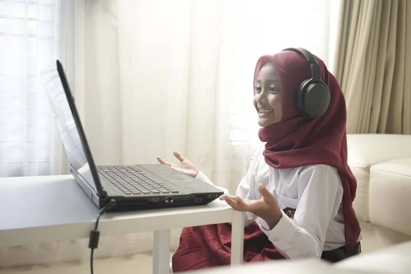 Seorang Gadis Kecil Yang Lucu Mengenakan Hijab Merah Melakukan Sesuatu Stok Gambar Bebas Royalti