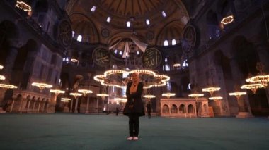 Dünyanın en büyük camisi Ayasofya 'nın içinde duran başörtülü güzel Asyalı kadın. İslam 'ın sembolü ve büyük turizm beldesi