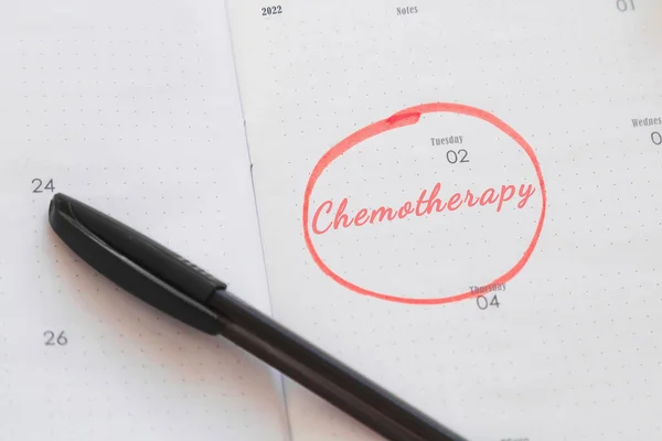 calendar planner notebook with inscription chemotherapy date marked and circled with marker, cancer treatment concept.