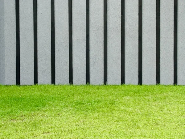푸른 잔디와 회색과 검은색 벽 — 스톡 사진