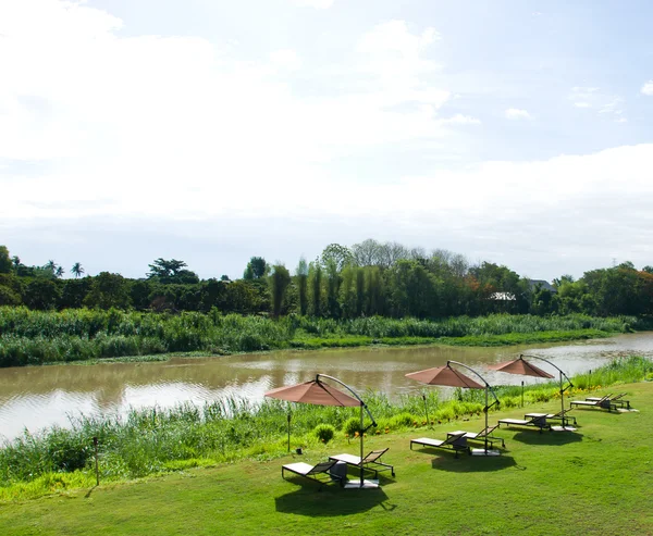 El paraguas y el asiento en el jardín — Foto de Stock