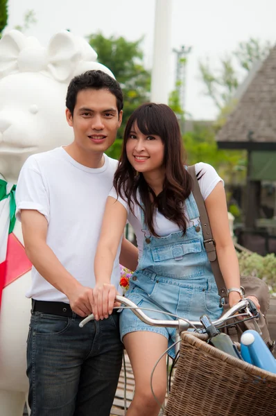 Retrato de una feliz pareja sonriendo a la cámara con la bicicleta — Foto de Stock