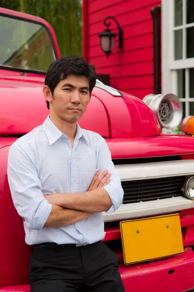 Een Aziatische man kruis zijn arm en mager tegen vrachtwagen — Stockfoto