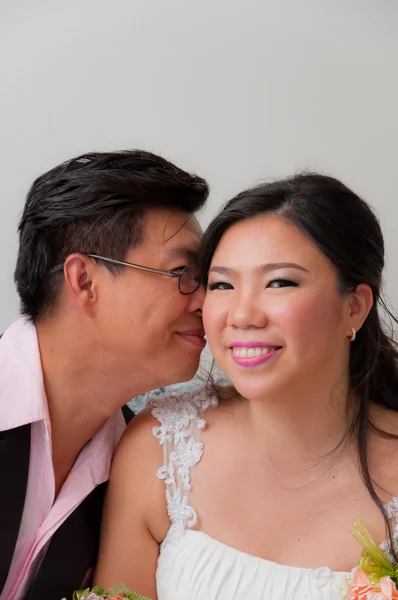 Bruden kyssar brudgummen leende till kamera — Stockfoto