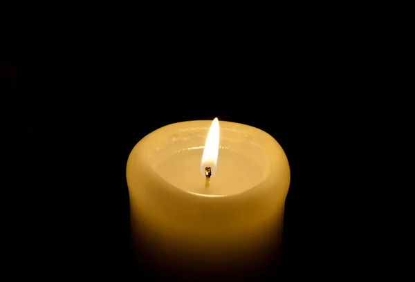 A candle lights up in the darkness — Stock Photo, Image