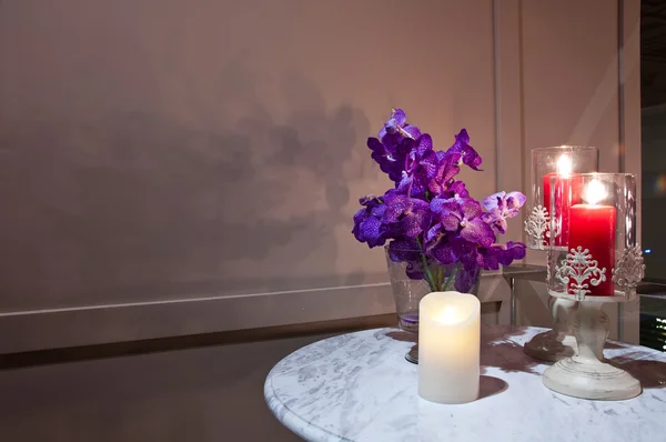 Las velas y la orquídea púrpura sobre la mesa —  Fotos de Stock