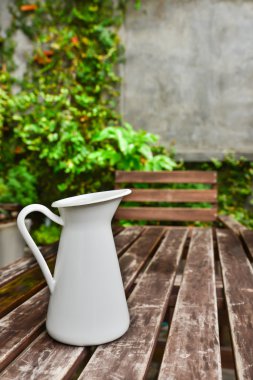 ahşap masa üzerinde beyaz bir sürahi