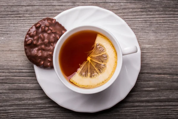 Taza caliente de té en taza blanca con galletas de limón y chocolate . —  Fotos de Stock