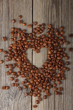 kahve çekirdekleri ahşap masa üzerinde yapılan kalp şekli.