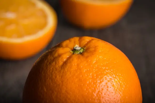 Primer plano de fruta naranja en la superficie de madera. Enfocado en la parte superior de la parte delantera naranja —  Fotos de Stock