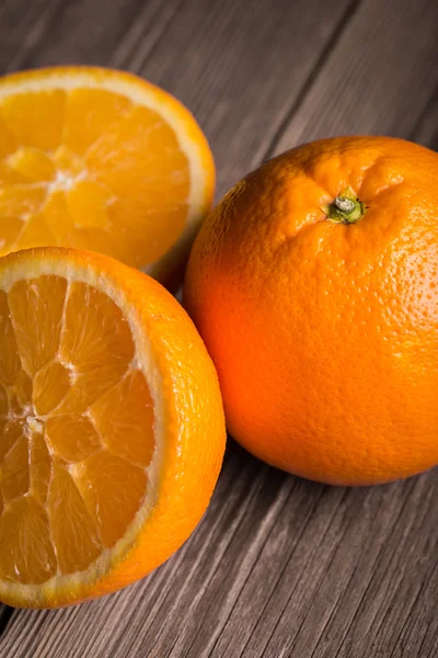 Close-up of orange fruit on wooden table. Focused on the top of the right orange. — Stock Photo, Image