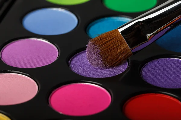 Close-up of colorful eyeshadow palette with brush — Stock Photo, Image