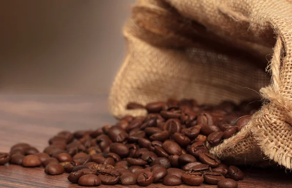 Coffee beans in coffee bag wooden surface