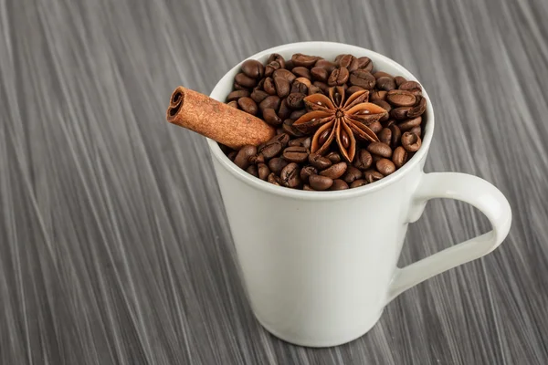 Copo de café branco cheio de grãos de café — Fotografia de Stock