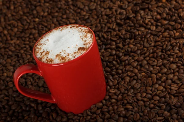 Taza de café con leche sobre fondo de granos de café — Foto de Stock