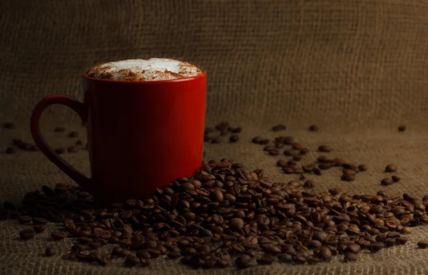 Kopje koffie latte op koffie bonen achtergrond — Stockfoto