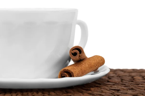 White cup of coffee with cinnamon sticks — Stock Photo, Image