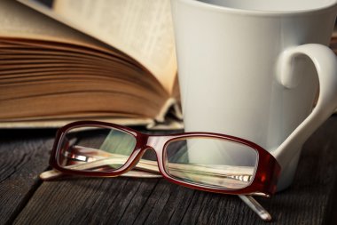 sıcak çay bardağı, kitap, gözlük