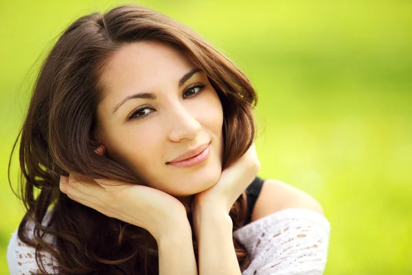 Изображение молодой красивой женщины в летнем парке, улыбающейся — стоковое фото