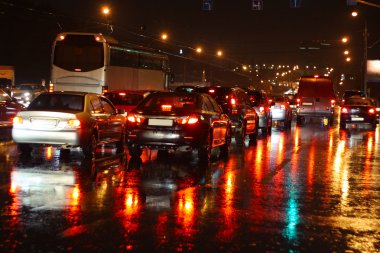 Wet night road with cars at stopline. Autumn, rain, reflections. clipart