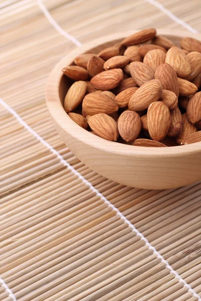 Bowl of almonds on straw serviette — Stock Photo, Image